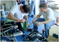 Chris Wakim and a crew member work on the transmission